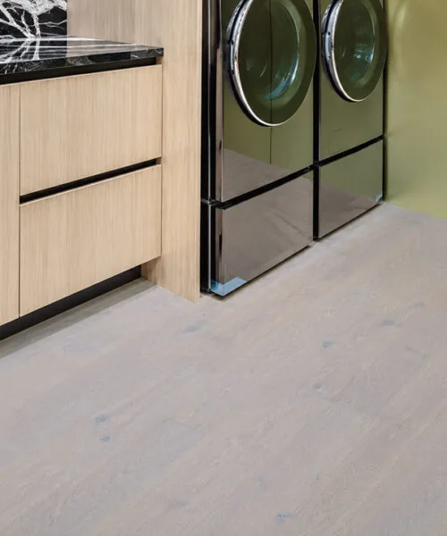 Nordic Oak - 3/8" (9.5mm) - Forna Natural Composite Flooring with Waterproof Hydrowood Core (NNorO9.5) Light natural oak floating floor installed in a stylish laundry room with green cabinetry