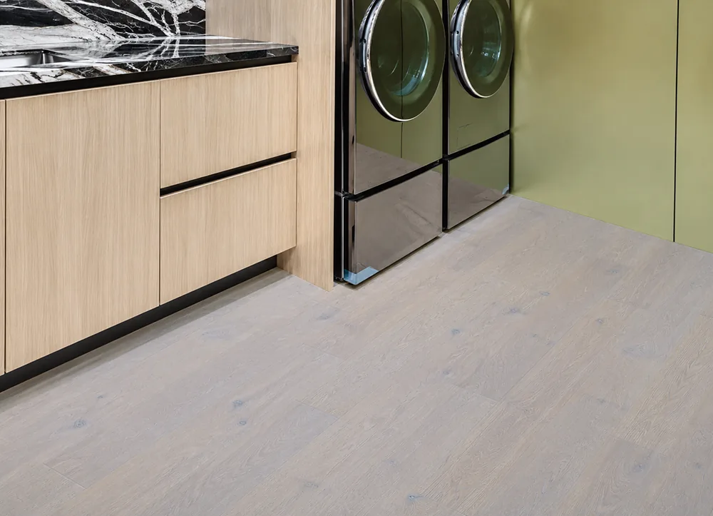 Nordic Oak - 3/8" (9.5mm) - Forna Natural Composite Flooring with Waterproof Hydrowood Core (NNorO9.5) Light natural oak floating floor installed in a stylish laundry room with green cabinetry