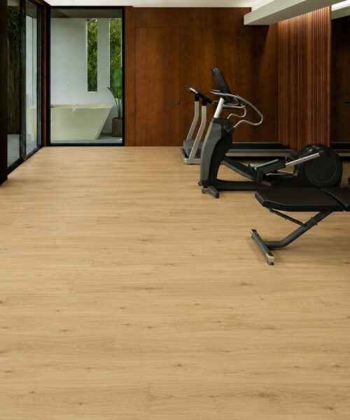 Durable Long Beach Swiss Design cork floating flooring installed in a modern home fitness room with premium exercise equipment and warm natural oak appearance.