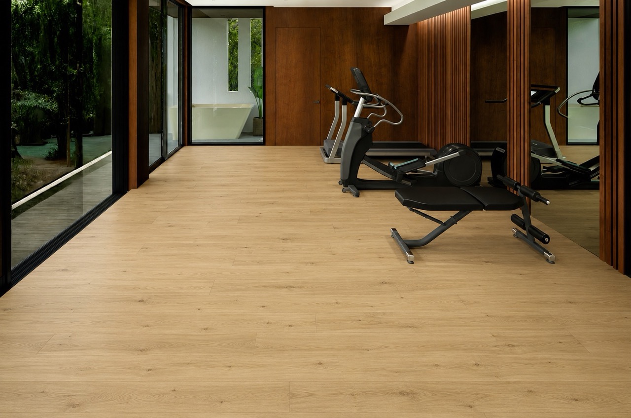 Long Beach - 7/16" (11mm) - Swiss Design Floating (FLB11) Durable Long Beach Swiss Design cork floating flooring installed in a modern home fitness room with premium exercise equipment and warm natural oak appearance.