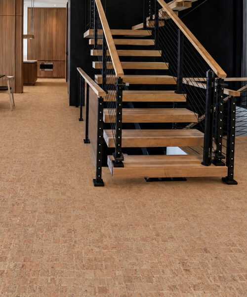 Sustainable ParCork cork flooring in natural brown tones extends around an open wood-and-metal staircase.