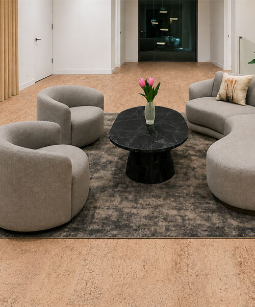 Rhythm – 7/16″ (11mm) – Swiss Real Cork Floating (FRhy11) Rhythm sustainable cork flooring frames curved lounge chairs and sculptural black tables in a modern living room.