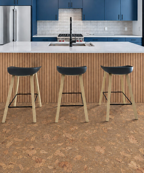 Caramel-beige Rococo cork flooring with organic swirls complements blue cabinets and a wood-slat island.
