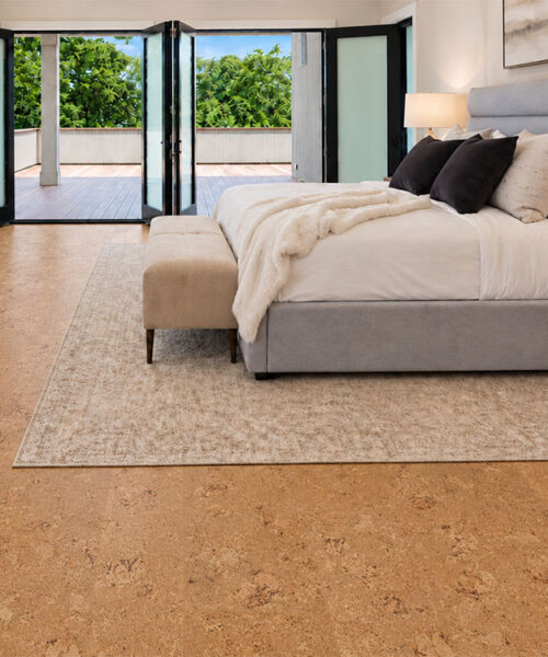 Salami - 1/2" (12mm) - Cork Floating (FSal12) Golden Salami floating cork flooring frames a gray upholstered bed and garden-facing folding doors.