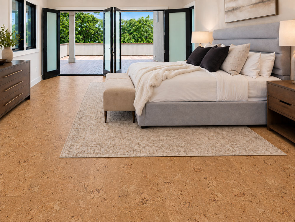 Salami - 1/2" (12mm) - Cork Floating (FSal12) Golden Salami floating cork flooring frames a gray upholstered bed and garden-facing folding doors.