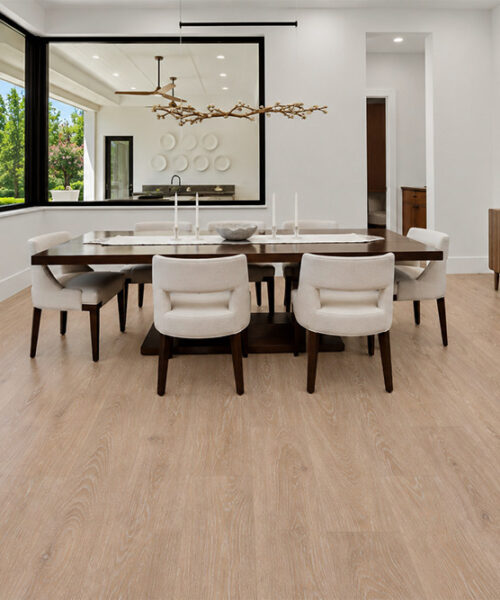 Sandstorm - 7/16" (11mm) - Swiss Design Cork Floating (FSan11) Sustainable Sandstorm cork flooring with soft tan wood grain brightens a modern dining room with large windows and a sculptural chandelier.
