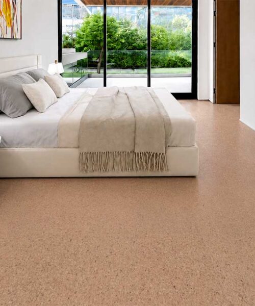 Comfortable Seaside cork flooring in a soft tan tone surrounds a neutral upholstered bedroom suite.