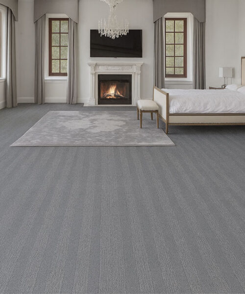 Spacious bedroom with Swiss Serpent Luxe leather floating floors, soft gray finish adding sophistication to a warm, inviting retreat.