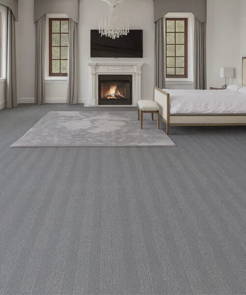 Spacious bedroom with Swiss Serpent Luxe leather floating floors, soft gray finish adding sophistication to a warm, inviting retreat.
