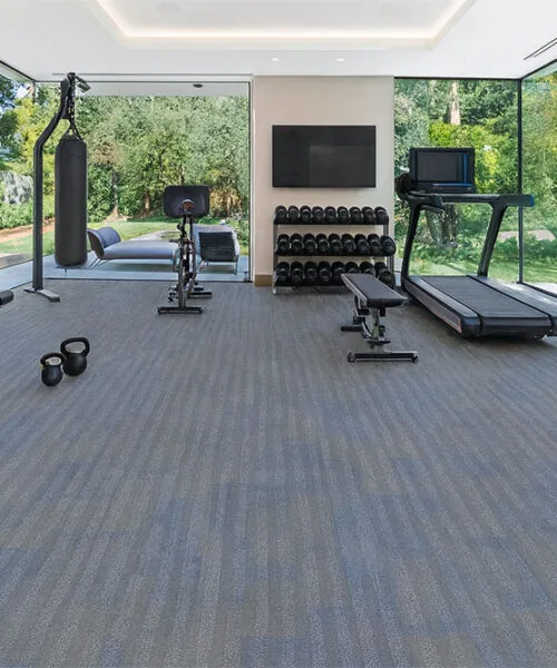 Luxury home fitness room showcasing Swiss Serpent Luxe leather flooring, resilient blue-gray surface ideal for workouts and training.