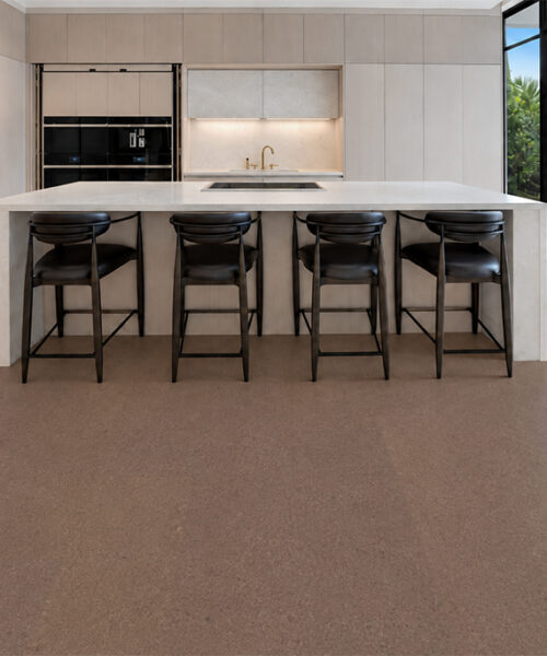Shoreline 10mm natural mid-brown floating cork flooring surrounds a marble island with black stools.