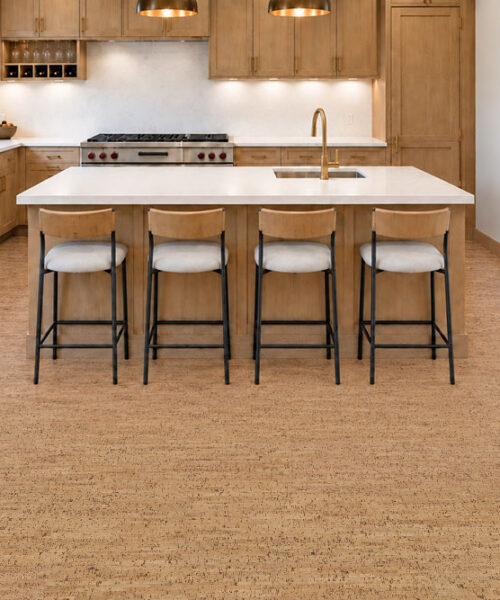Silver Birch - 5/16" (8mm) - Cork Glue Down Tile (GSB8) Silver Birch golden ribbon cork floor planks surround a wood kitchen island with four counter stools.