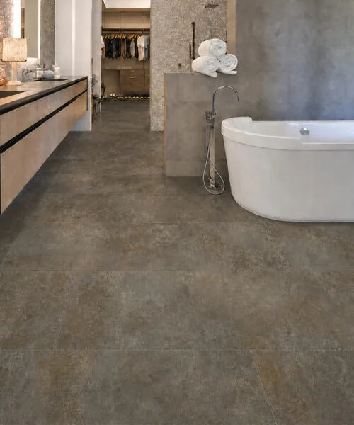 Sunlit Stone - 19/64" (7.5mm) - Swiss Techslate (MSunSt7.5) aterproof brown-gray Sunlit Stone Techslate floor in a modern spa bathroom with a white soaking tub