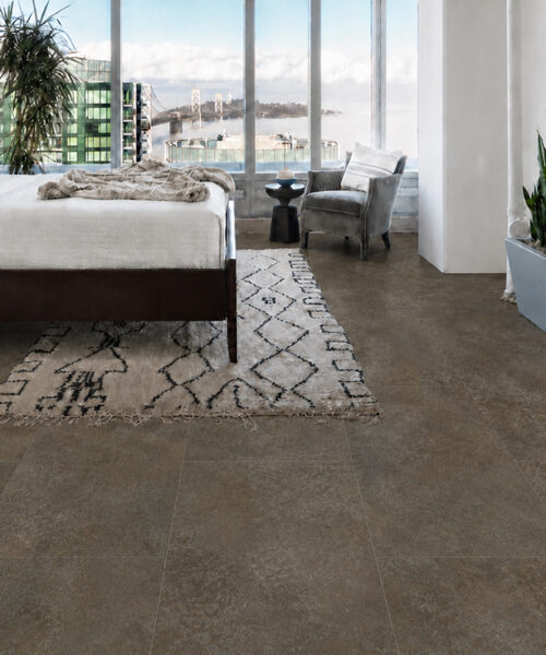 Contemporary bedroom featuring Sunlit Stone Swiss Techslate floor with a textured taupe stone appearance.