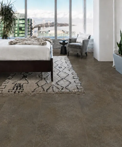 Contemporary bedroom featuring Sunlit Stone Swiss Techslate floor with a textured taupe stone appearance.