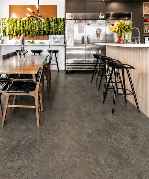 Sunlit Stone - 19/64" (7.5mm) - Swiss Techslate (MSunSt7.5) Open kitchen and dining area with durable Sunlit Stone Techslate flooring in a brown-gray stone finish.