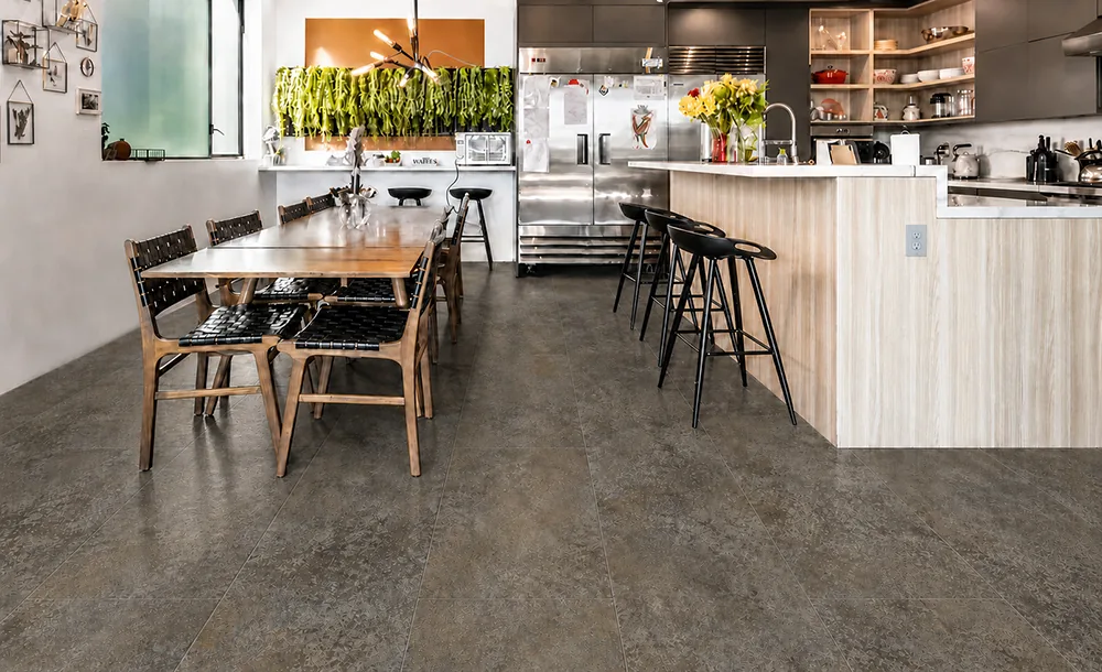 Sunlit Stone - 19/64" (7.5mm) - Swiss Techslate (MSunSt7.5) Open kitchen and dining area with durable Sunlit Stone Techslate flooring in a brown-gray stone finish.