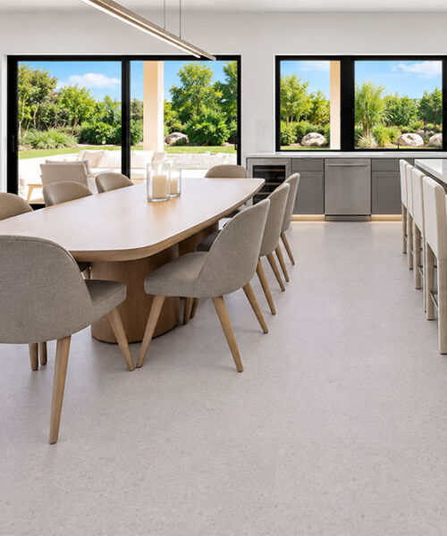 Sustainazzo - 25/64" (10mm) - Cork Floating (FSus10) Sustainazzo white speckled cork floor planks complement an open kitchen with a marble island and dining table.