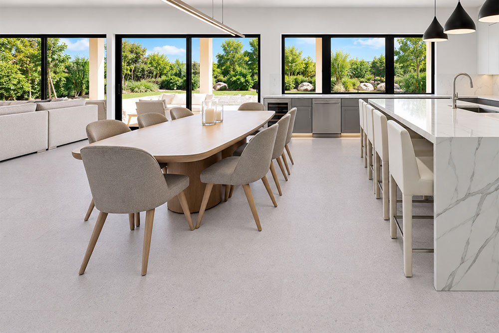 Sustainazzo - 25/64" (10mm) - Cork Floating (FSus10) Sustainazzo white speckled cork floor planks complement an open kitchen with a marble island and dining table.