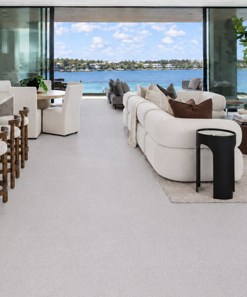 Sustainazzo - 25/64" (10mm) - Cork Floating (FSus10) Sustainazzo 10mm Cork Floating Flooring flows through a waterfront kitchen and living space with white furnishings.