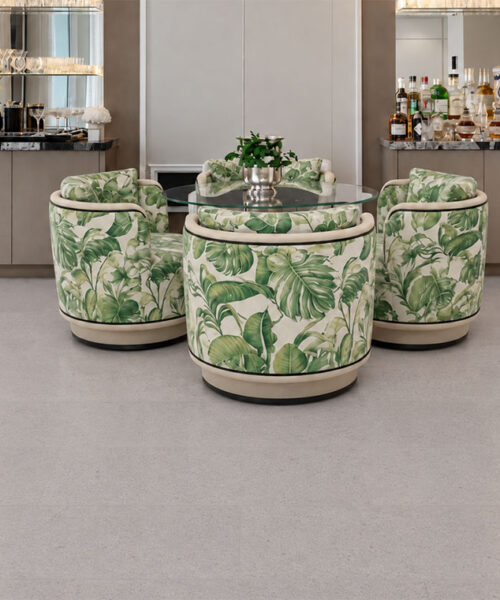 Sustainazzo - 25/64" (10mm) - Cork Floating (FSus10) Sustainazzo natural cork flooring with white terrazzo styling supports a glass table and tropical-print dining chairs.