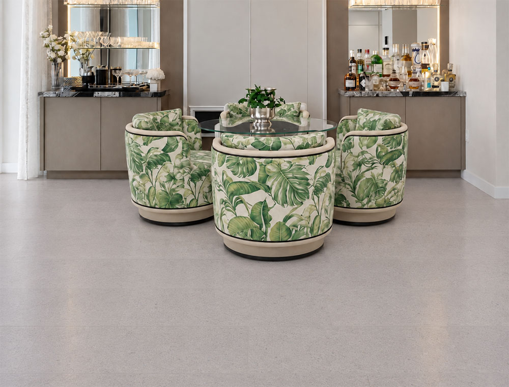 Sustainazzo - 25/64" (10mm) - Cork Floating (FSus10) Sustainazzo natural cork flooring with white terrazzo styling supports a glass table and tropical-print dining chairs.