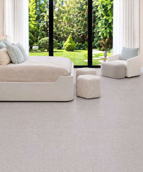 Sustainazzo - 25/64" (10mm) - Cork Floating (FSus10) Sustainazzo light-toned cork floor planks extend across a serene bedroom with garden windows and neutral furniture.