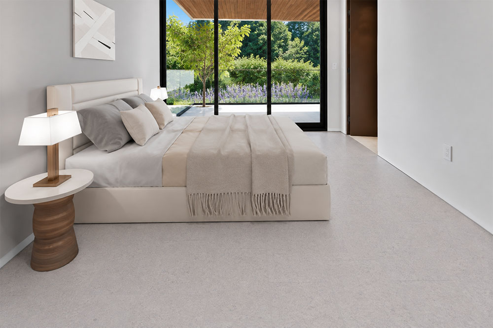 Sustainazzo - 25/64" (10mm) - Cork Floating (FSus10) Sustainazzo white terrazzo-look cork flooring complements a minimalist bedroom with soft bedding and patio views.