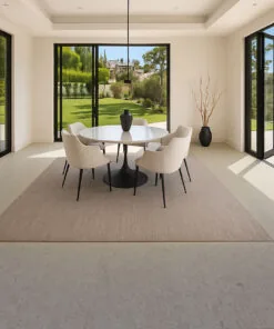 Light gray Swiss cork floating flooring in modern dining room with round table, soft chairs, and large glass doors