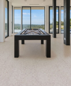 Modern game room with pool table on light gray cork flooring, large windows, and panoramic outdoor views