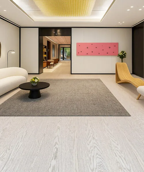 Luxury lobby-style living room showcasing Swiss Snow Cap real wood floating flooring, modern cream sofa, sculptural lounge chair, and minimalist décor.