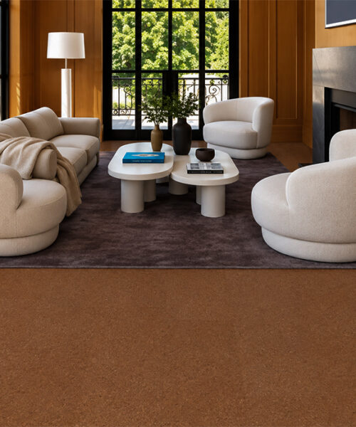 Venetian - 25/64" (10mm) - Cork Floating (FVen10) Venetian 10mm natural cork flooring in warm reddish-brown complements rounded ivory seating and wood-paneled walls.