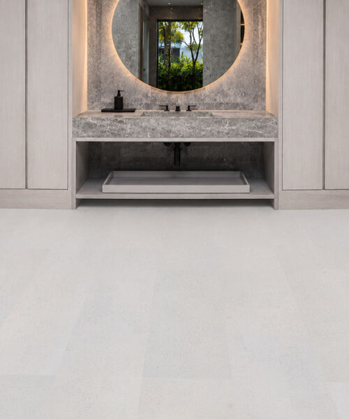 Contemporary hospitality lounge featuring White Leather cork flooring with a soft white leather-look finish, seamless planks, and modern cabinetry.