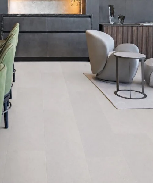 Contemporary hospitality lounge featuring White Leather cork flooring with a soft white leather-look finish, seamless planks, and modern cabinetry.