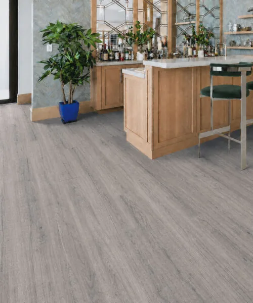 Wild Oak - 13/32" (10.5mm) - Design Cork Floating (FWO10.5) Contemporary home bar featuring medium-gray wood-grain cork flooring and natural wood cabinetry.