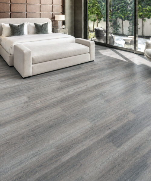 Sunlit contemporary bedroom with textured gray oak-look cork plank flooring.