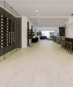 Contemporary wine cellar with glass walls and Vertical Swiss cork flooring, offering a seamless transition to the open living area with elegant marble finishes.