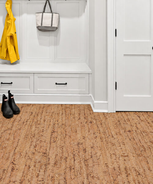 Natural-brown Woodflow 12mm cork floor planks with flowing linear texture brighten a white mudroom.