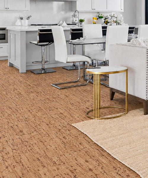 Warm Woodflow natural cork flooring unifies an open white kitchen, dining area, and waterfront living room.