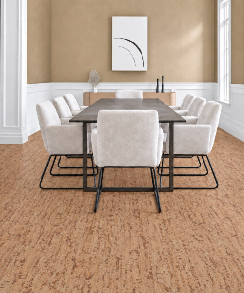 Medium-brown Woodflow cork flooring with organic linear grain grounds a bright dining room with cream chairs.
